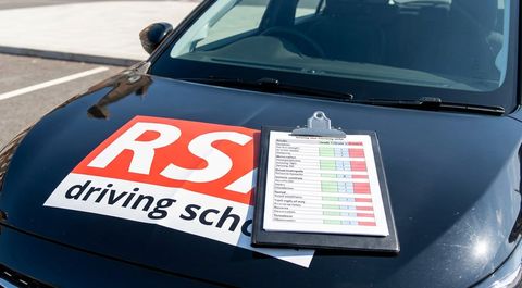 Driving test marking sheet on a clipboard on an RSA car bonnet
